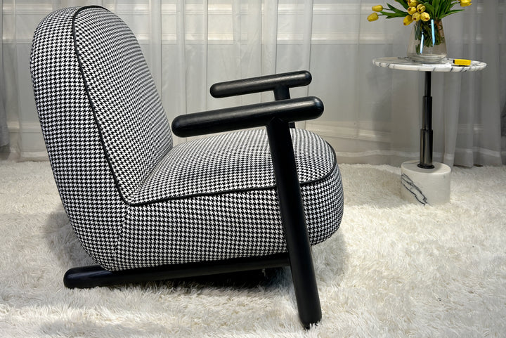 Black and white checkered armchair in a room with a small table and flowers.