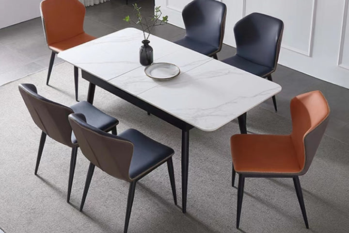 Dining table with six chairs in two colors, one of which is empty.