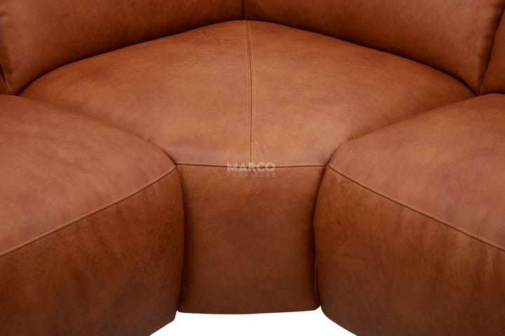 Brown leather sectional sofa with 'Marco' branding.