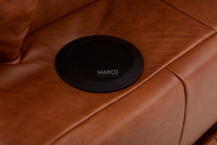 Black circular coaster with 'MARCO' branding on a brown leather surface