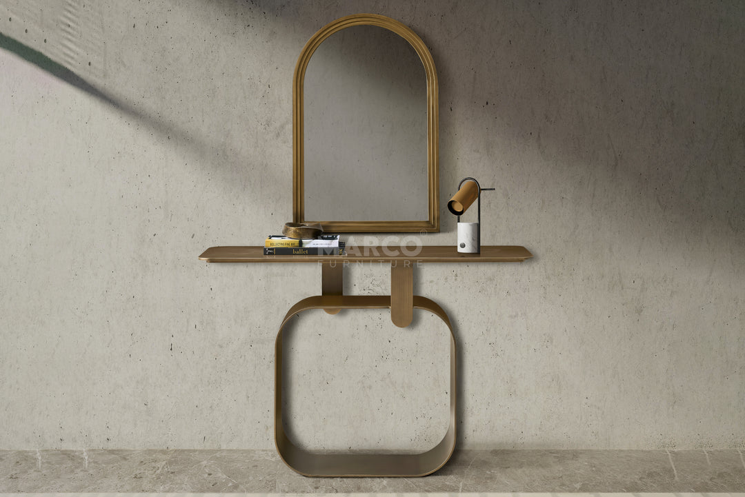 Console table with mirror and decorative items against a concrete wall.