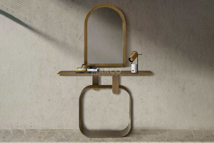 Console table with mirror and decorative items against a concrete wall.