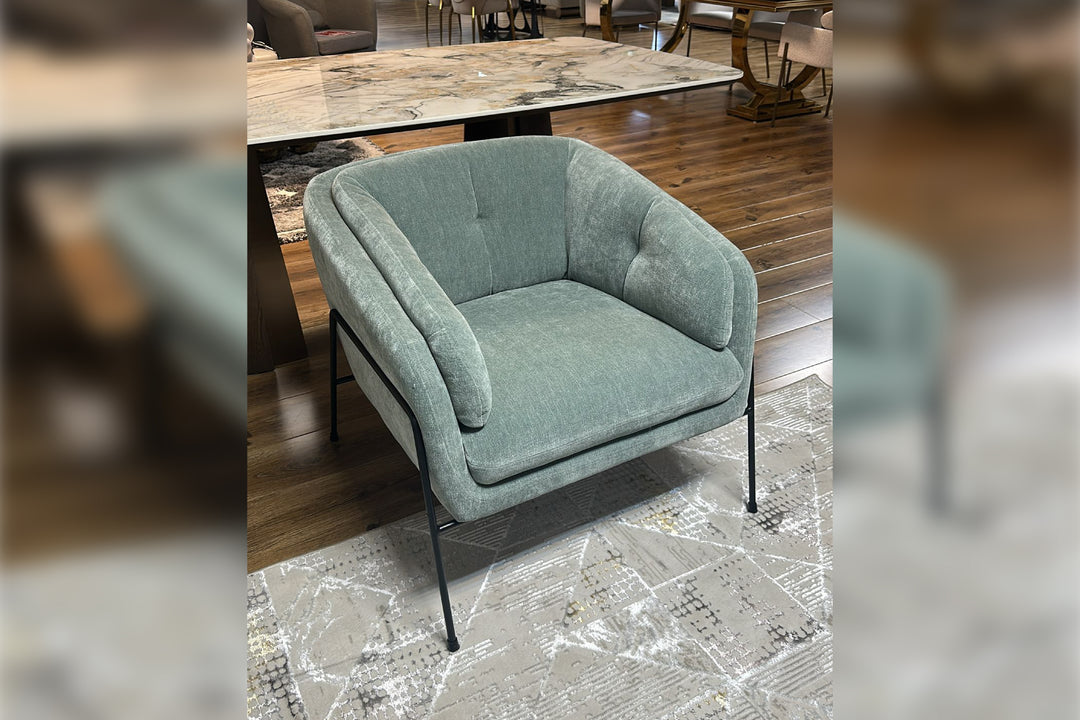 Green armchair in a room with wooden flooring and a table.