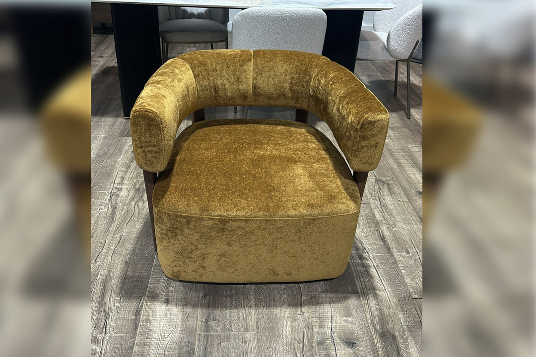 Gold velvet armchair on a wooden floor