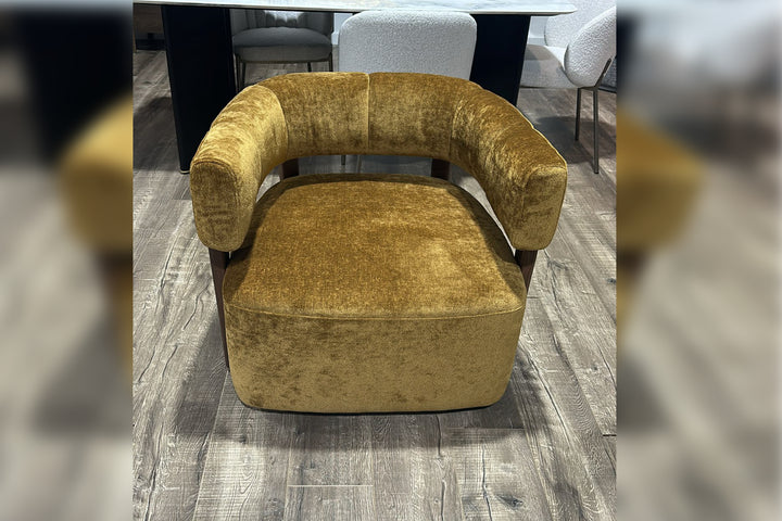 Gold velvet armchair on a wooden floor