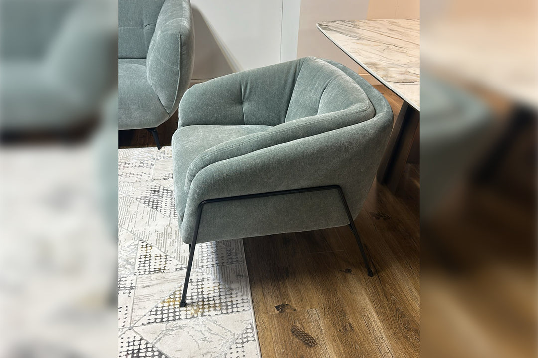 Gray armchair on a wooden floor with a blurred background