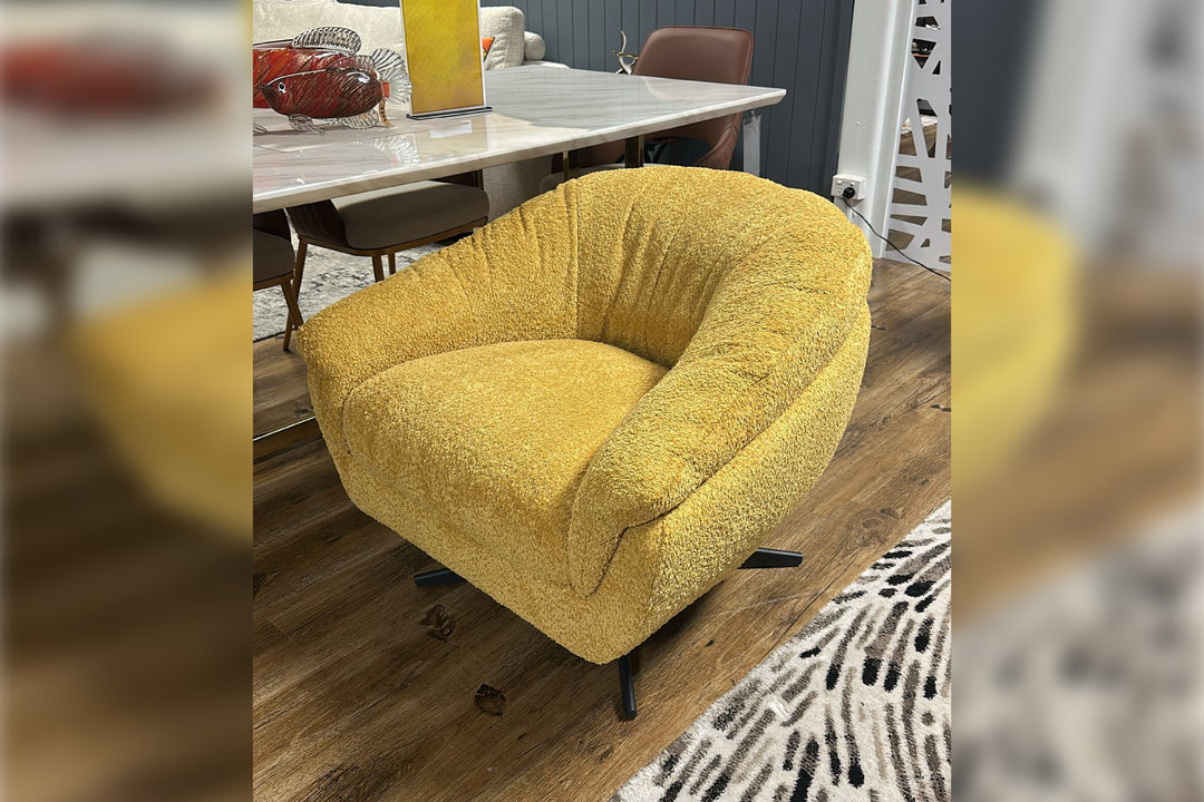 Yellow armchair in a room with a dining table and chairs.