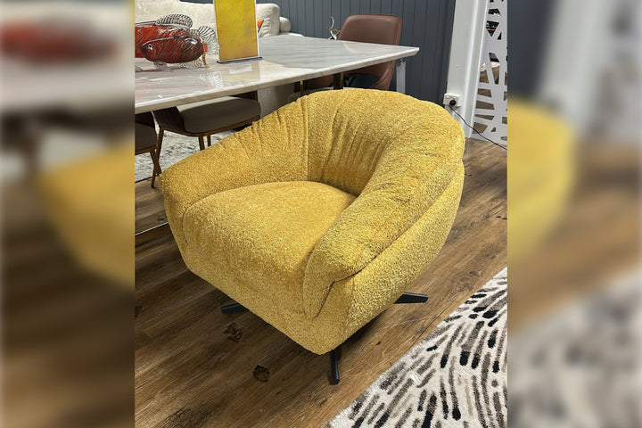 Yellow armchair in a room with a dining table and chairs.