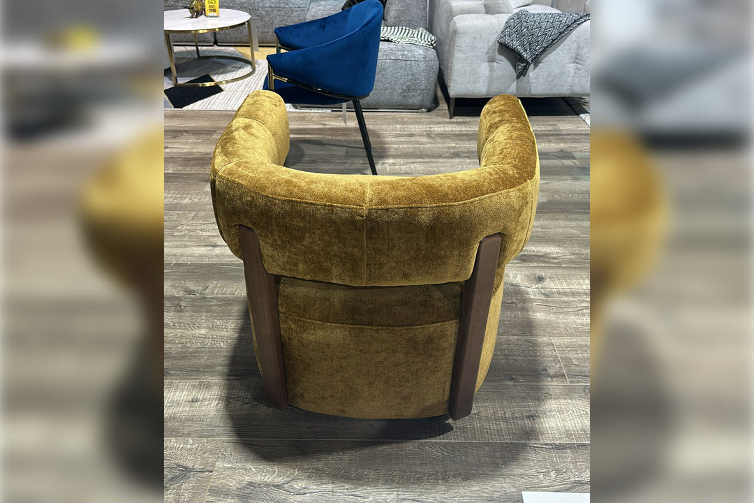 Yellow armchair in a room with gray flooring and other furniture.