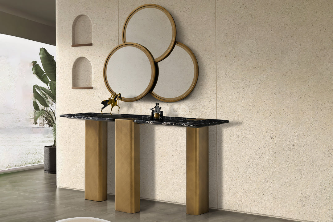 Bathroom vanity with marble countertop and round mirrors on a textured wall.