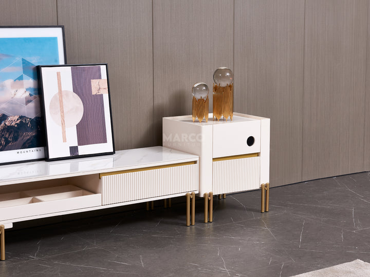 Modern white side table with gold legs next to a TV stand.