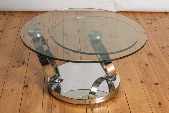 Glass coffee table with chrome base on wooden floor