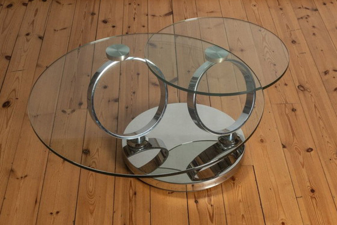 Glass coffee table with metal ring design on wooden floor