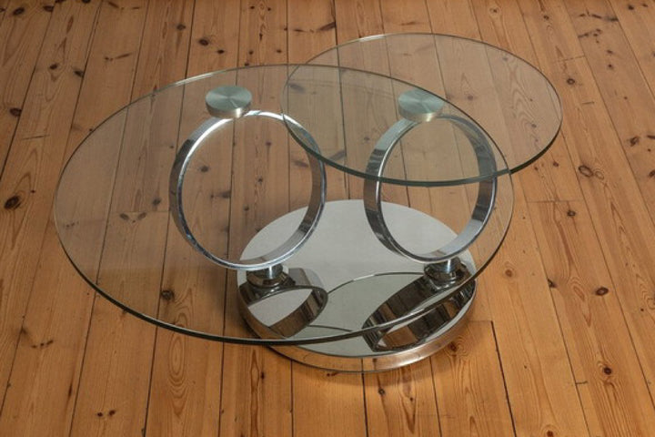Glass coffee table with metal ring design on wooden floor