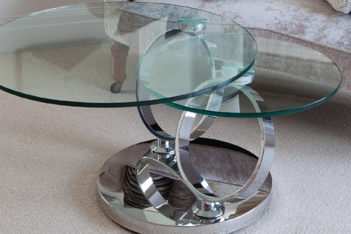 Glass coffee table with chrome base on beige carpet.