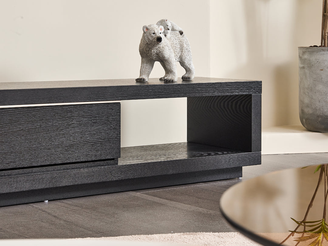 Black wooden cabinet with a bear figurine on top in a neutral room.