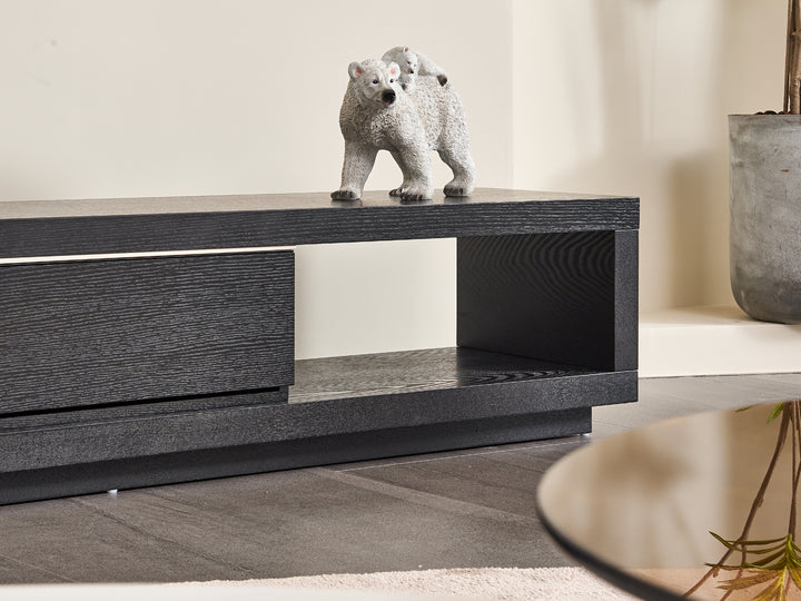 Black wooden cabinet with a bear figurine on top in a neutral room.