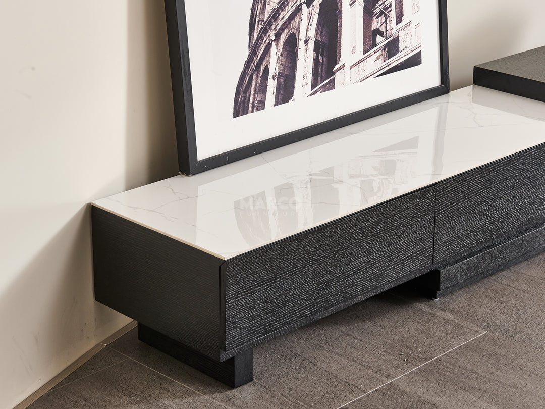 Black and white TV stand with a framed picture on a wall.