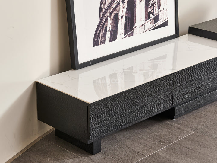 Black and white TV stand with a framed picture on a wall.