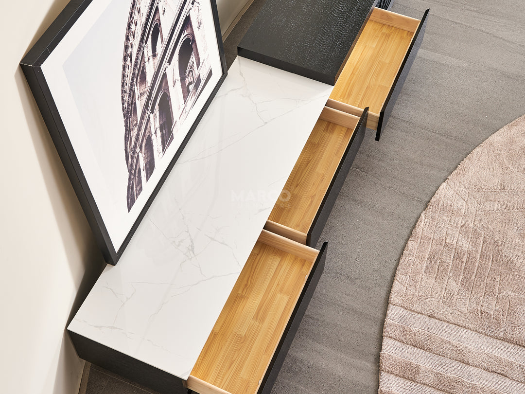 Modern coffee table with built-in drawers and a framed picture on one side.
