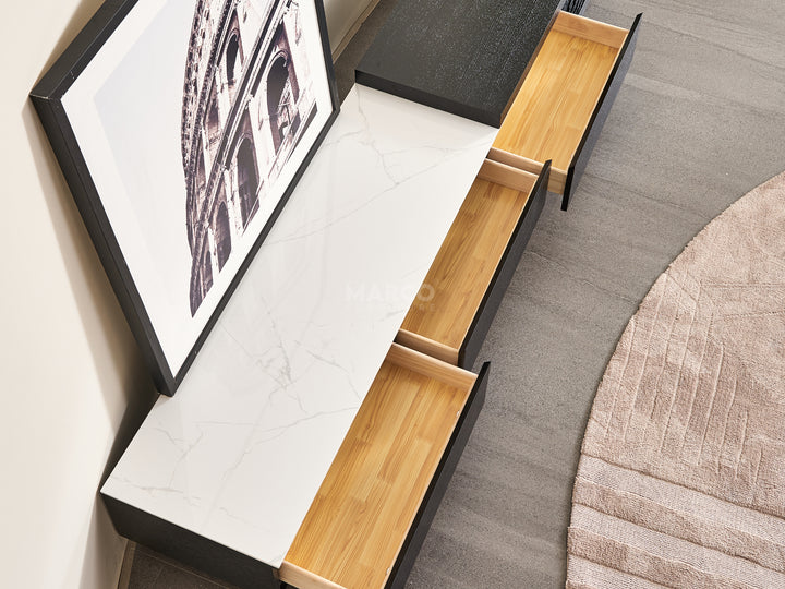 Modern coffee table with built-in drawers and a framed picture on one side.