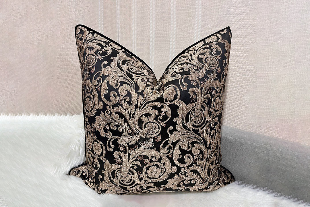 Decorative black and gold pillow on a white sofa