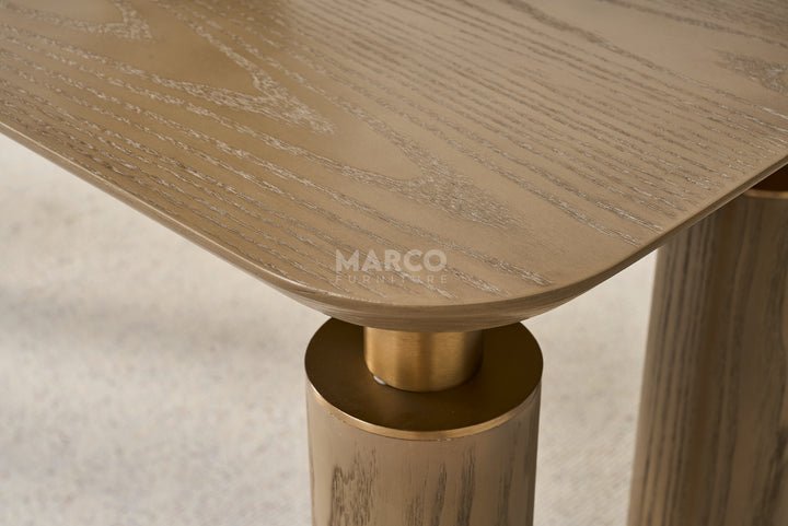 Wooden table with gold base and 'Marco' branding on a neutral background