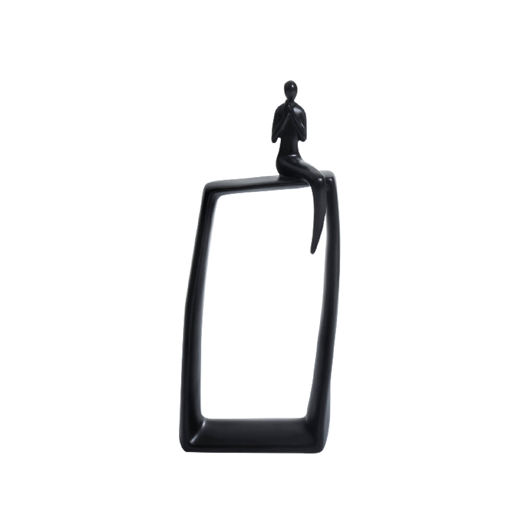 A black ceramic sculpture of a sitting alone man figure on a glossy black rectangular base.