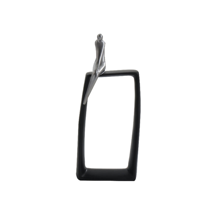 A black and silver abstract art sculpture featuring a glossy silver figurine on a black rectangular base with a negative space.