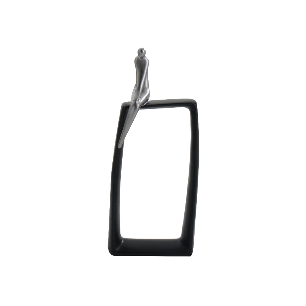 A black and silver abstract art sculpture featuring a glossy silver figurine on a black rectangular base with a negative space.