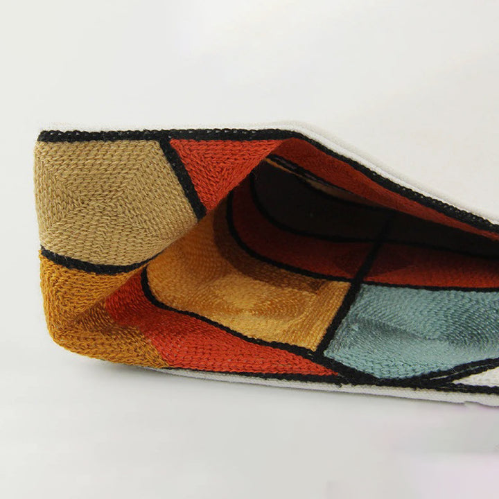 Colorful geometric-patterned clutch bag on a white background