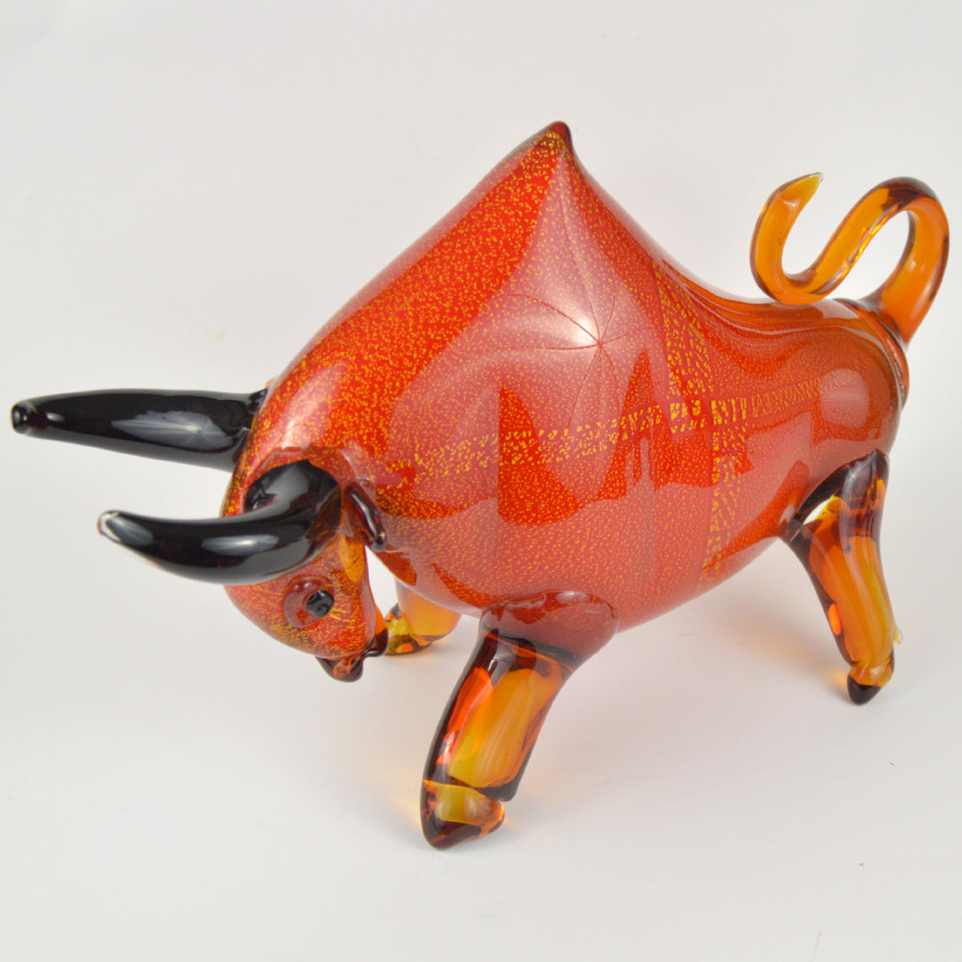 Glass bull figurine with orange and brown colors on a white background