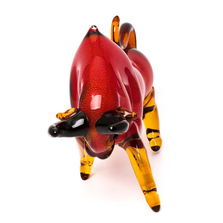 Glass sculpture of a red and yellow animal figure on a white background