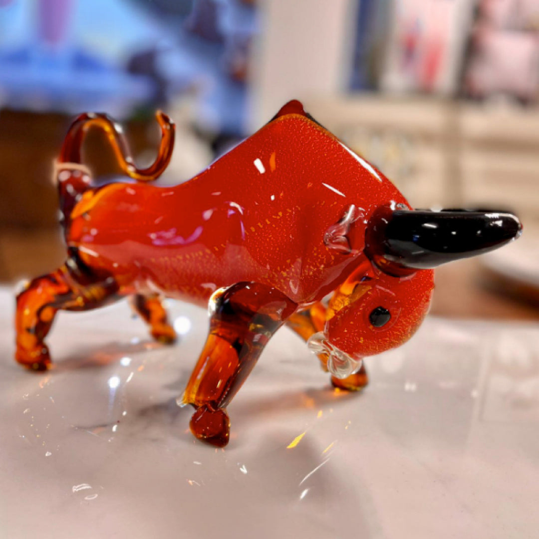Glass figurine of a red dog on a white surface with a blurred background