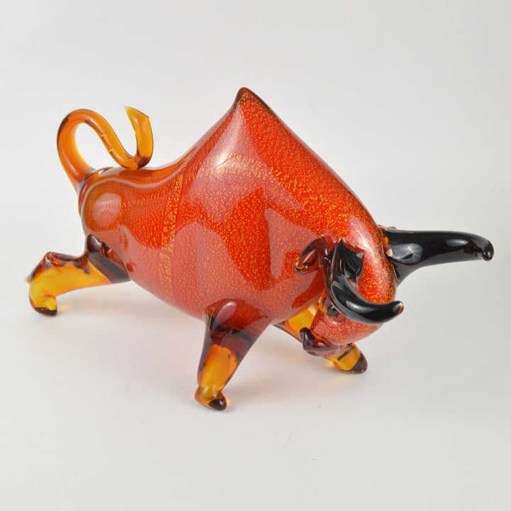 Glass bull figurine with orange and brown colors on a white background