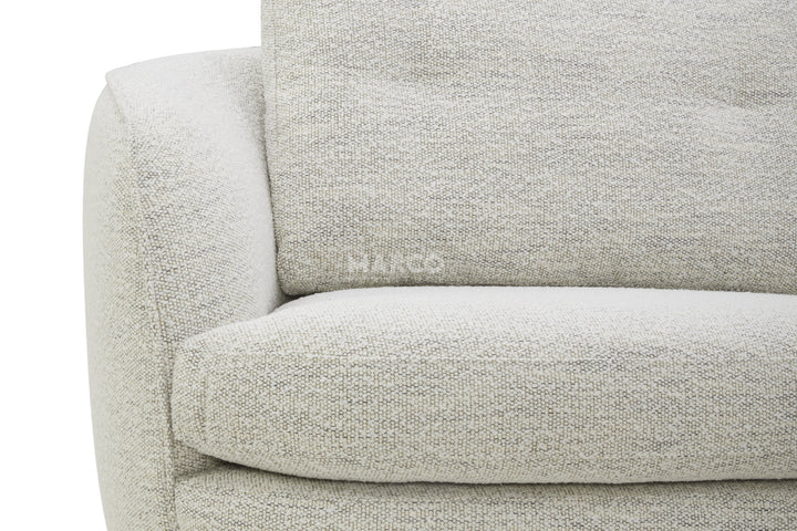 Close-up of a light gray sofa with 'MARCO' branding on a white background