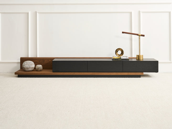 A modern TV unit with extendable sections, featuring natural walnut veneer and black oak veneer finishes, with three drawers and a brass handle.
