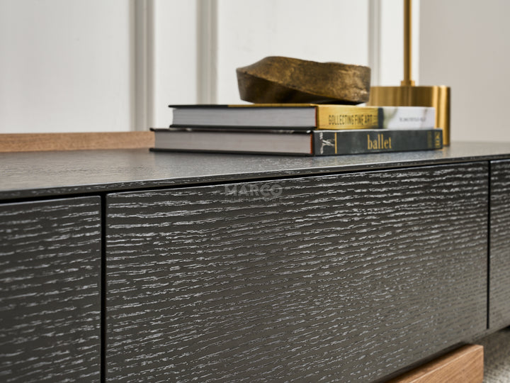 Dark wooden sideboard with books and decorative object.