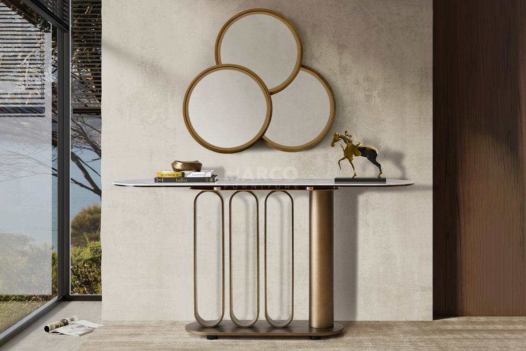 Console table with decorative mirrors and items against a neutral wall.