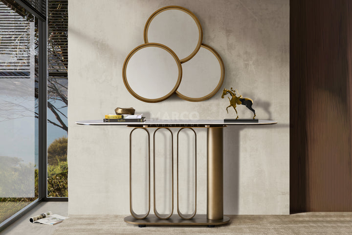 Console table with decorative mirrors and items against a neutral wall.