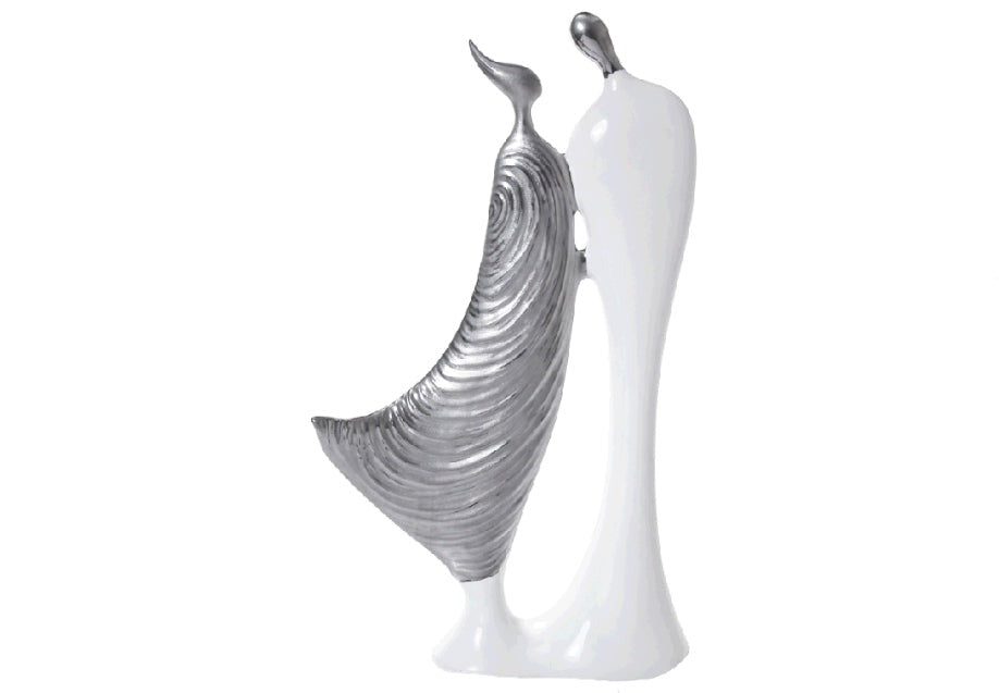 A pair of contemporary ceramic figurines of abstract human-like figures, one in glossy white and the other in textured silver/gold, placed on a white surface.