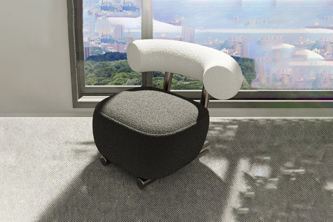 Modern chair with a gray seat and white backrest in a room with large windows showing a cityscape.