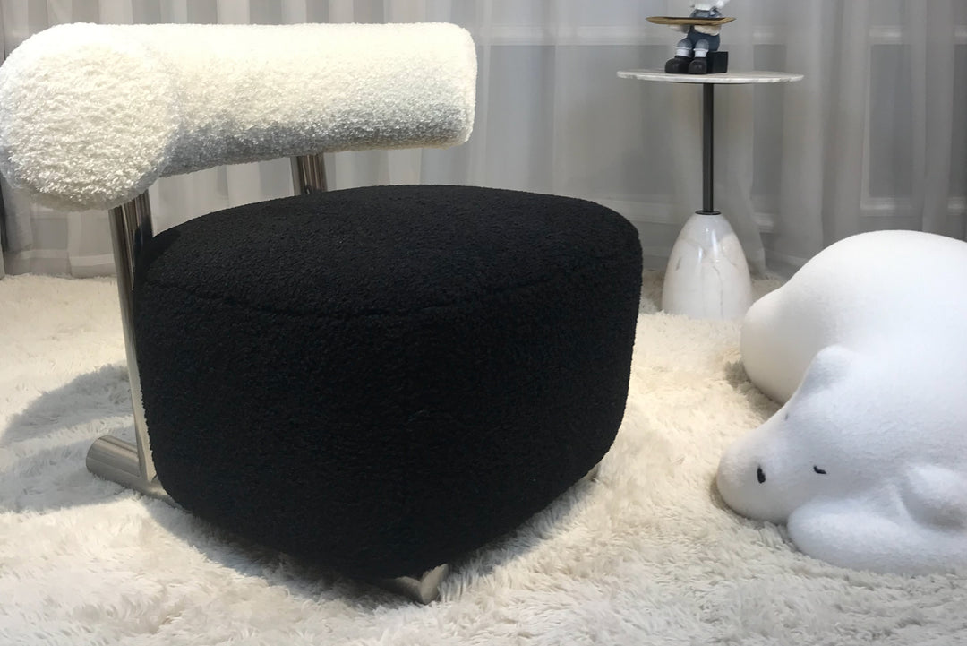 Black ottoman with textured top in a room setting