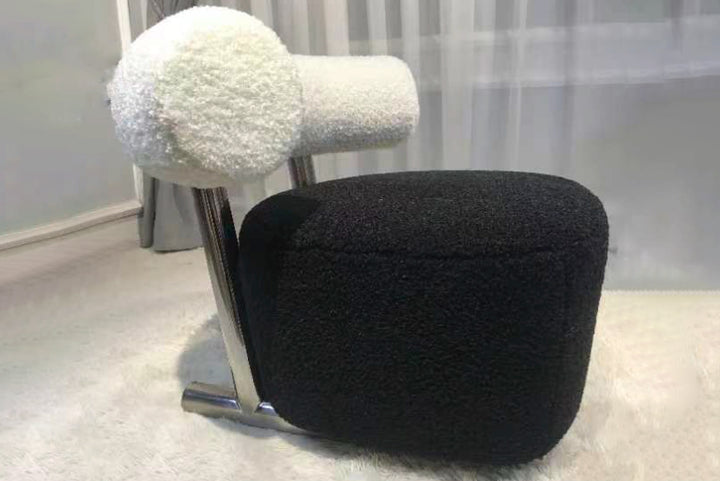 Black and white textured stool with chrome legs on a light gray floor.
