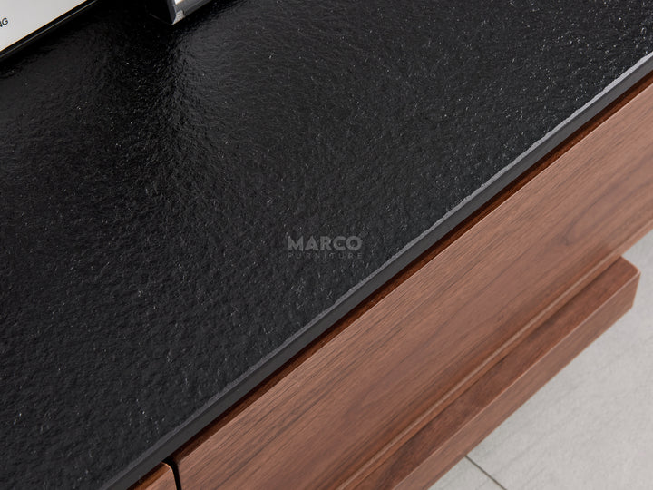 Close-up of a wooden drawer with a black leather cover.