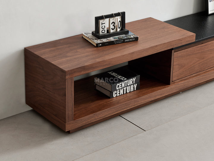 Wooden TV stand with shelves against a wall.