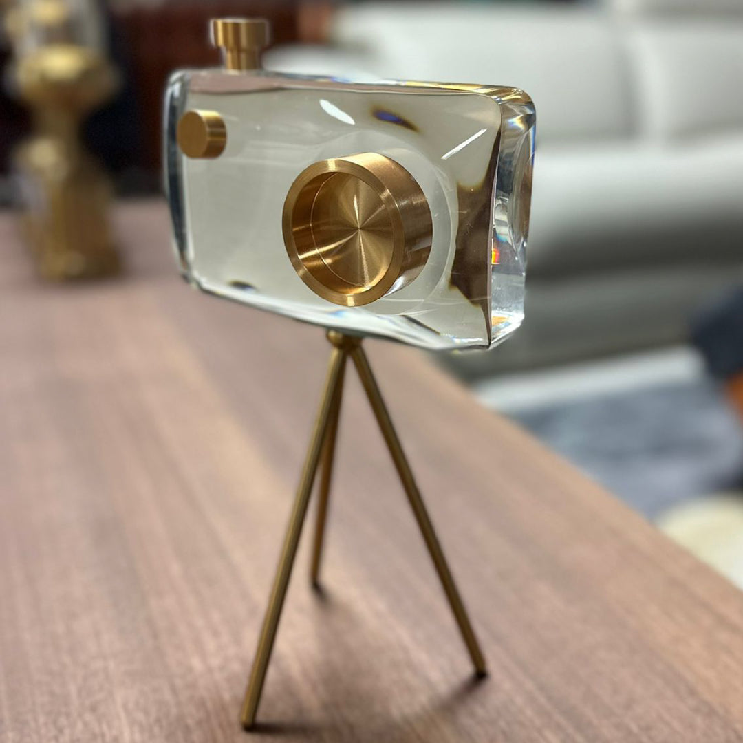 Decorative object with gold accents on a stand, placed on a surface.