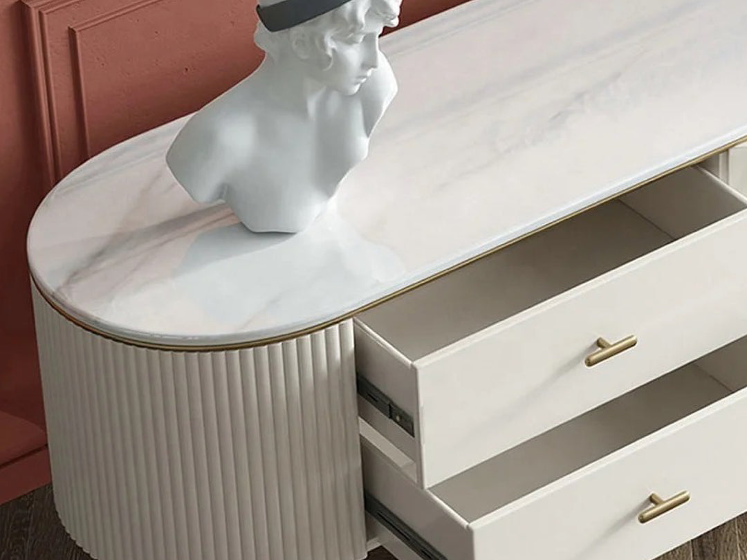 Marble-top dresser with a bust sculpture and open drawer.