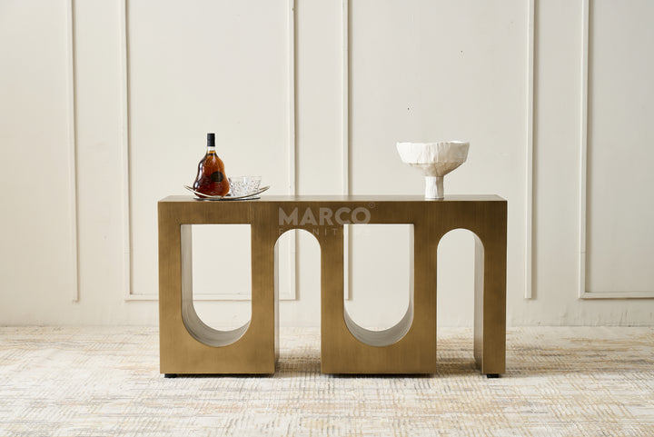Bronze side table with 'MARCO' branding against a neutral wall.