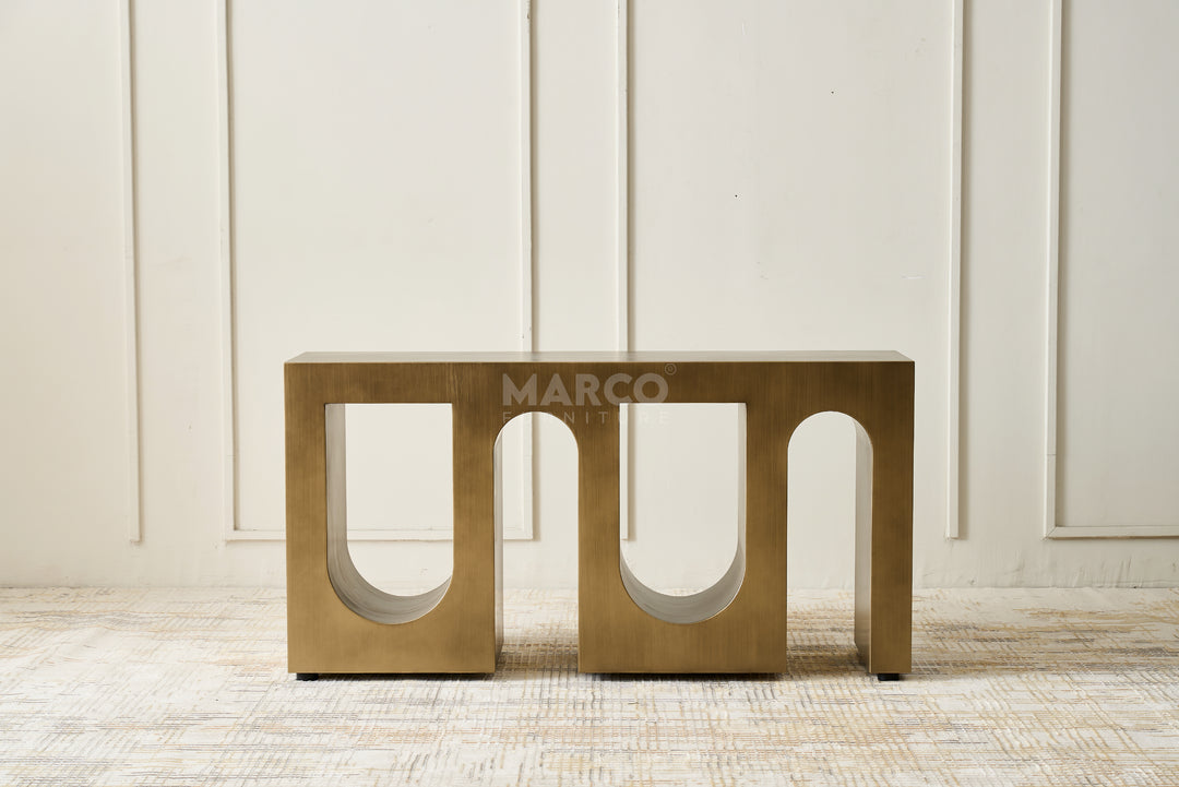 Bronze-colored metal bench with 'MARCO' branding against a light wooden panel background